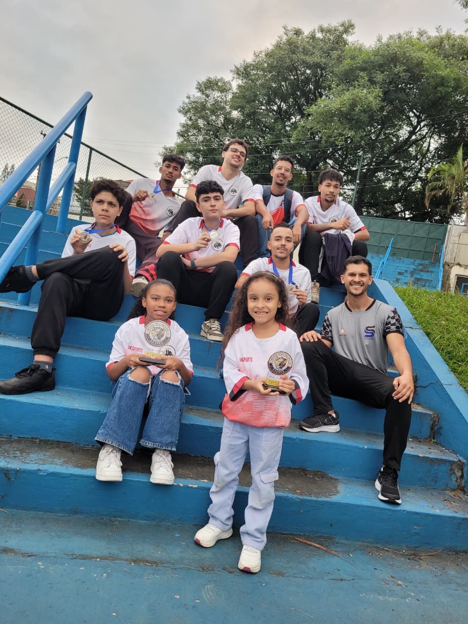 Jovens atletas do Xadrez Taboão com troféus nas arquibancadas